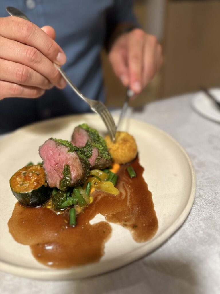 Rosa gebratenes Nüsschen vom Weidelamm, Gremolatastreusel, Zucchini, Arancino, Bohnen, reduzierte Lammjus © Murmelz